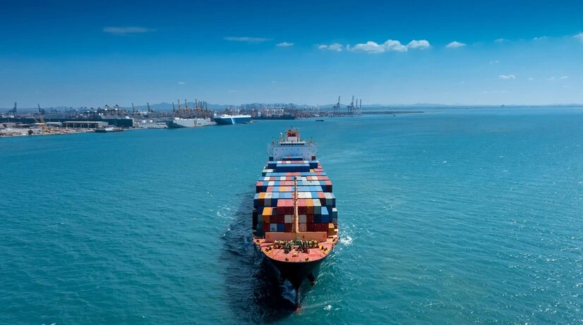 container ship approaching port with clear skies