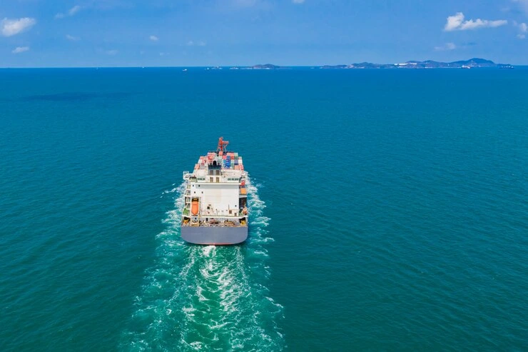 container ship leaving a wake in the blue ocean